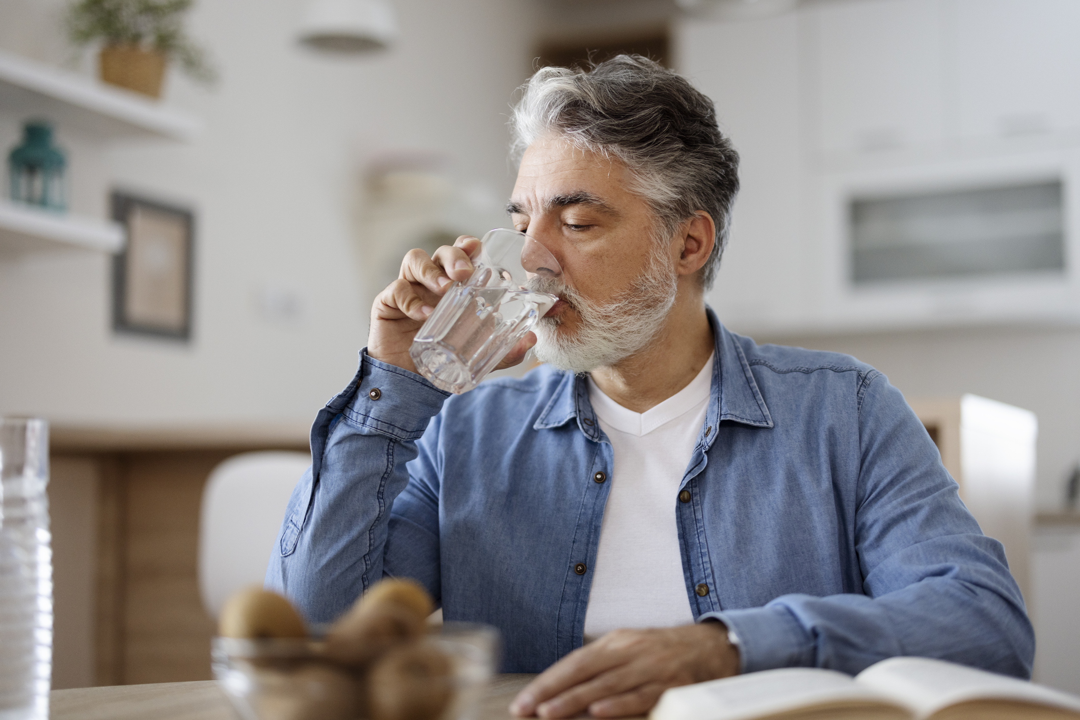 Man drinkt water in zijn keuken